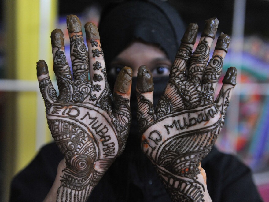 An Indian Muslim woman poses showing her hands decorated with mehendi (henna) during 'Chand Raat' or 'Night of the Moon' in Hyderabad on August 30, 2011, traditionally held on the eve of the festival of Eid al-Fitr.