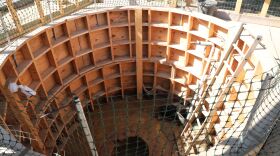The well archaeologists excavated is surrounded by scaffolding. The last two weeks have been a frenzy of activity for archaeologists. (Image: Laura Philion)