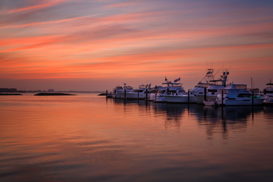 Boats docked at a marina during a sunset.