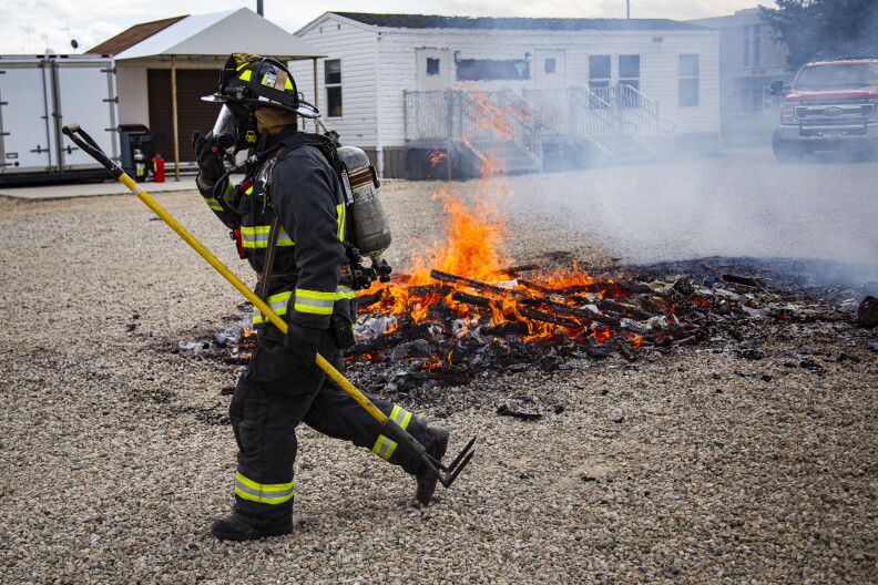 A Boise firefighter walks by all that remains of the poorly prepared home at a recent demonstration fire.