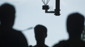 Passersby walk under a surveillance camera  part of facial recognition technology test.