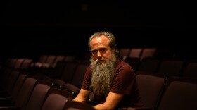 a man posing for a photograph in an empty theater 