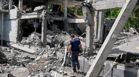 A rescuer walks among ruins of a school in Kharkiv, partially destroyed by a rocket as Russian forces are solidifying their hold on the eastern Donbas region and pushing steadily towards Ukraine's de facto administrative centre in that region, Kramatorsk.