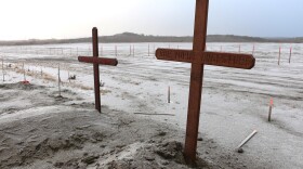 A wooden cross with the words "Four Yupiit Ancestors" marks the spot where the remains of four Yup'ik inhabitants taken from the region in 1907 were buried in November 2024 after being returned to the Orutsararmiut Traditional Native Council.