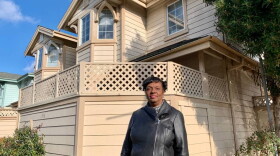 Gayla Newsome stands in front of her Oakland home. (Molly Solomon/KQED)