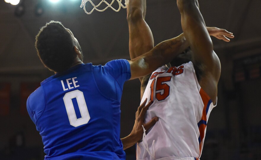 Despite getting a faceful of Kentucky’s Marcus Lee's (00) hand, Florida's John Egbunu (15) goes up strong for a dunk in the second half. Greenberry Taylor/WUFT News)