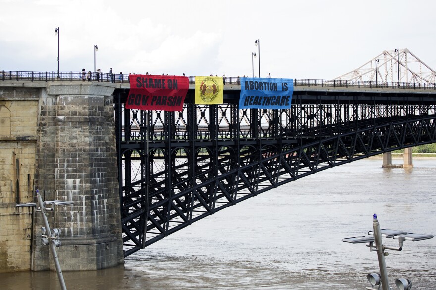 Planned Parenthood supporters walked onto the Eads Bridge to drop banners with a message to Missouri Gov. Mike Parson. 