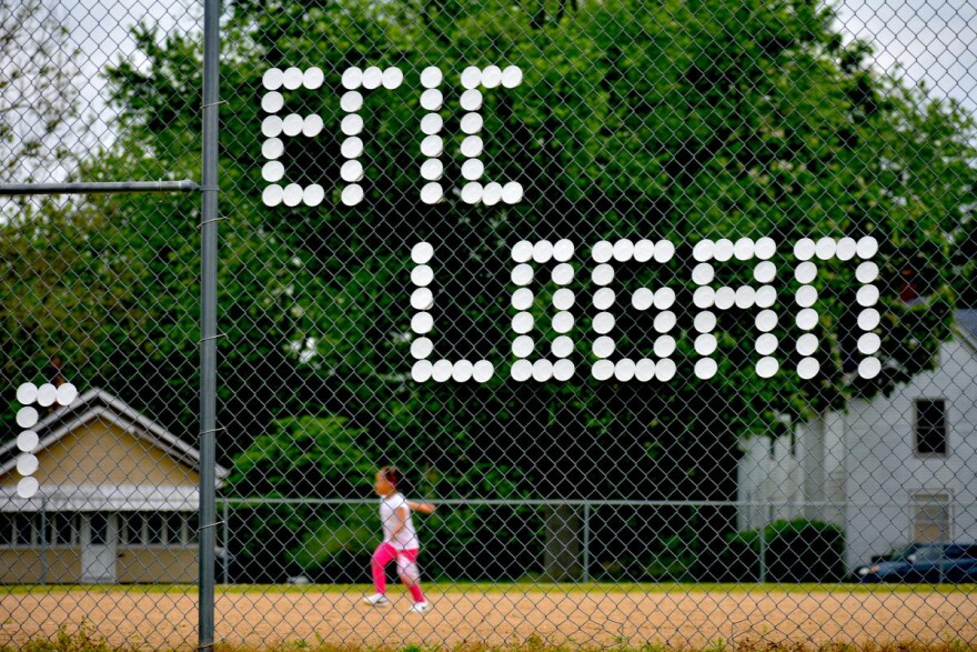 Eric Logan's name written in styrofoam cups on a fence surrounding a baseball field in South Bend.