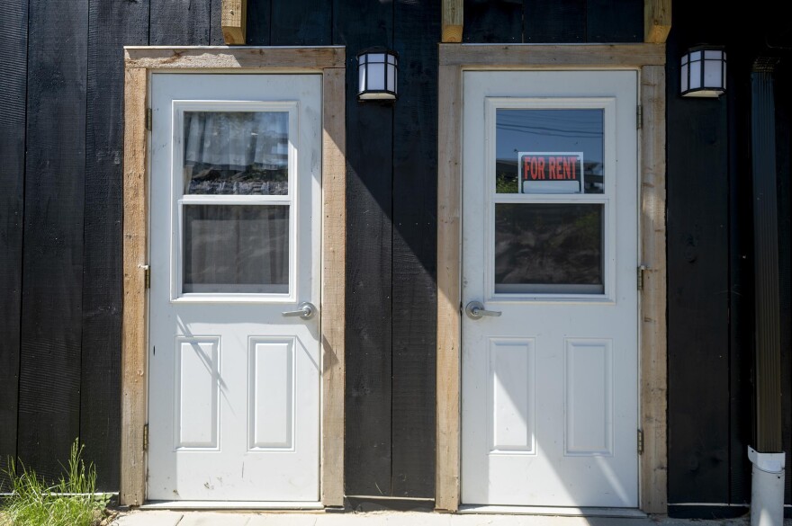 Two doors in a building, one with a "for rent" sign