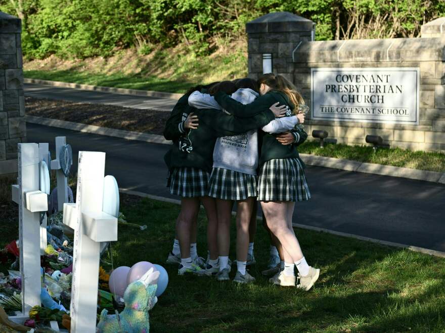 Girls embrace in front of a makeshift memorial for victims by the Covenant School building in Nashville on Wednesday.