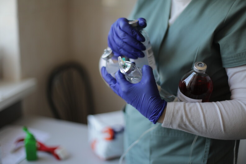 A nurse holds bottles of medications.