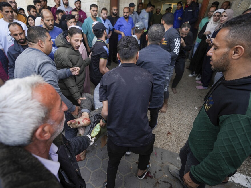 Palestinians carry a wounded person following an Israeli airstrike near the Al Aqsa hospital in Deir al Balah, Gaza Strip, Sunday, March 31, 2024.