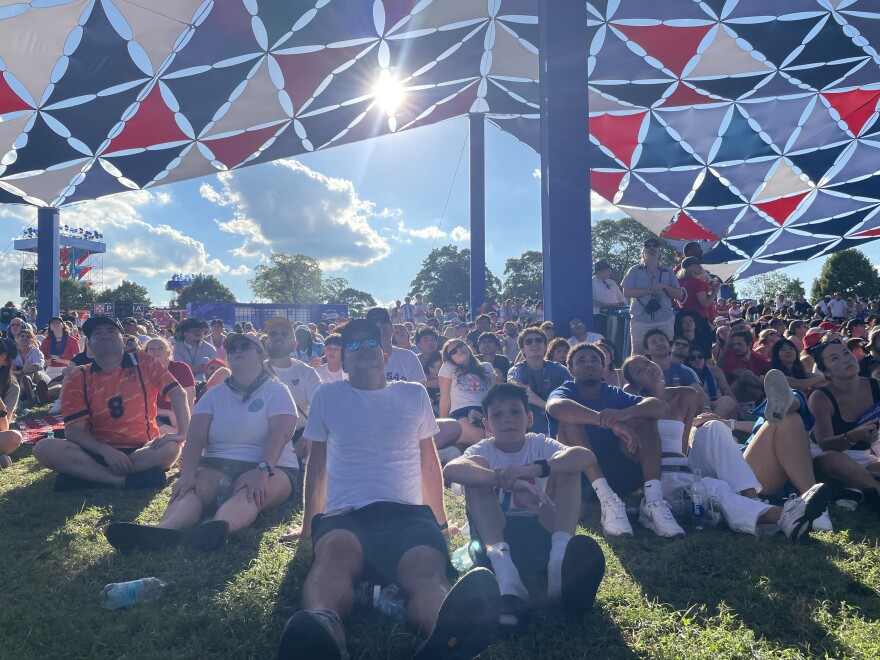 Soccer fans watch a World Cup match on the big screen under a bright, hot sun Saturday at FIFA Fan Fest.