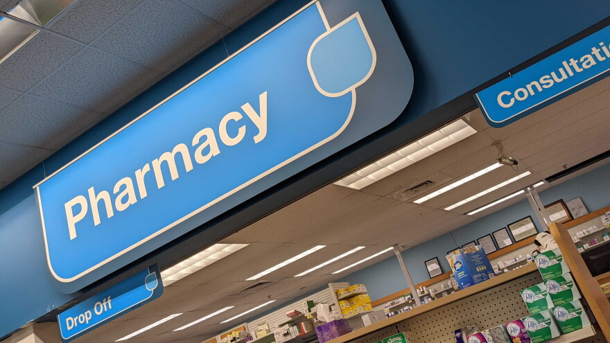 Inside a CVS Pharmacy with a blue pharmacy sign