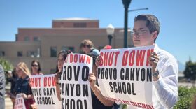 Demonstrators at a news conference make a show of support for parents suing the Provo Canyon School on June 15, 2026.