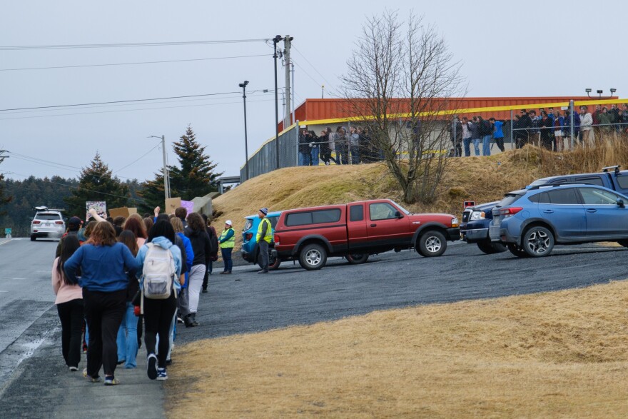 Kodiak Middle School students cheer as their high school counterparts passed them. (Brian Venua/KMXT)