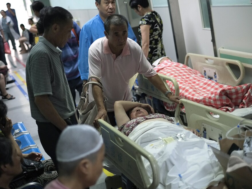 A man pushes his relative through a hallway crowded with patients waiting to receive medical treatment at a Beijing hospital in July 2013. Journalist Wu Si says gray income is just a fact of daily life in China — everyone ranging from teachers and doctors to officials accepts off-the-books payments.