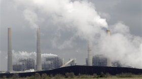 In this March 16, 2011 file photo, exhaust rises from smokestacks in front of piles of coal at NRG Energy's W.A. Parish Electric Generating Station in Thompsons, Texas.