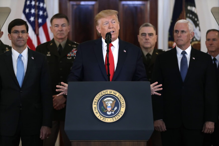 President Donald Trump addresses the nation from the White House on the ballistic missile strike that Iran launched against Iraqi air bases housing U.S. troops, Wednesday, Jan. 8, 2020, in Washington, as Vice President Mike Pence and others looks on. (Evan Vucci/AP)