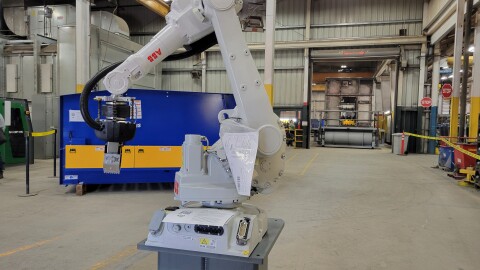 A metal robot arm on a stand