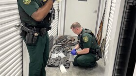 Escambia County, Fla., sheriff’s deputies collect guns and boxes of ammunition from a storage unit in Pensacola, Fla., on Nov. 27, 2024, that belonged to Stanley McDaniels as part of a domestic dispute criminal case. McDaniels, who took the photograph to document the seizure, later became the defendant in a landmark gun rights case that allowed people in Florida to openly carry guns. (Stanley McDaniels via X.com/Fresh Take Florida)