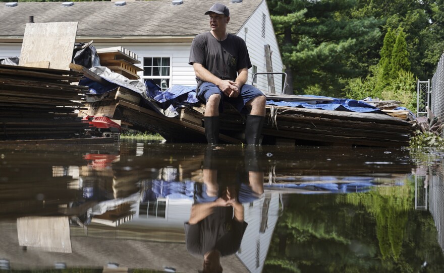 Frank Gounder sits in his flooded backyard, where his wood shop was also damaged by floodwaters, in Indianapolis, Sunday, Aug. 16, 2026.