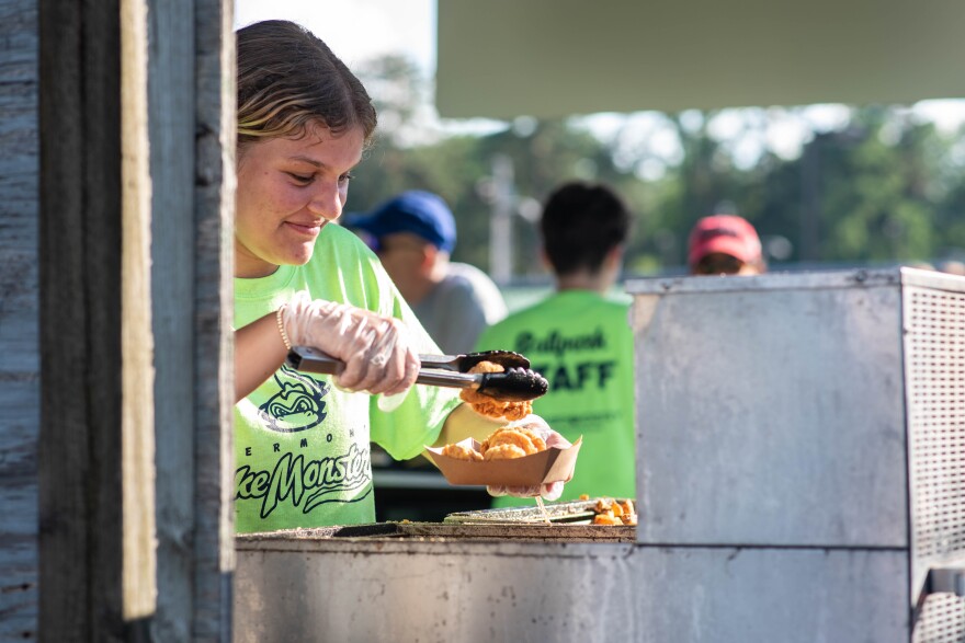 A person in a green shirt serving fried food