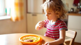 Little cute girl eating spaghetti