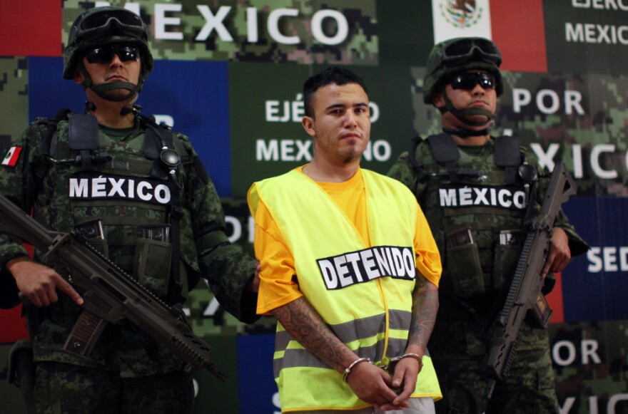 Army soldiers flank Daniel Ramírez, alias "El Loco," during his presentation to the media in Mexico City on Monday.