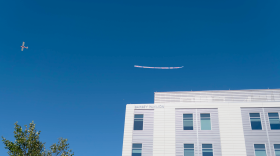 A biplane tows a banner over Cape Cod Hospital in Hyannis with the message "Cancer Awareness. Stay Positive And Fight."
