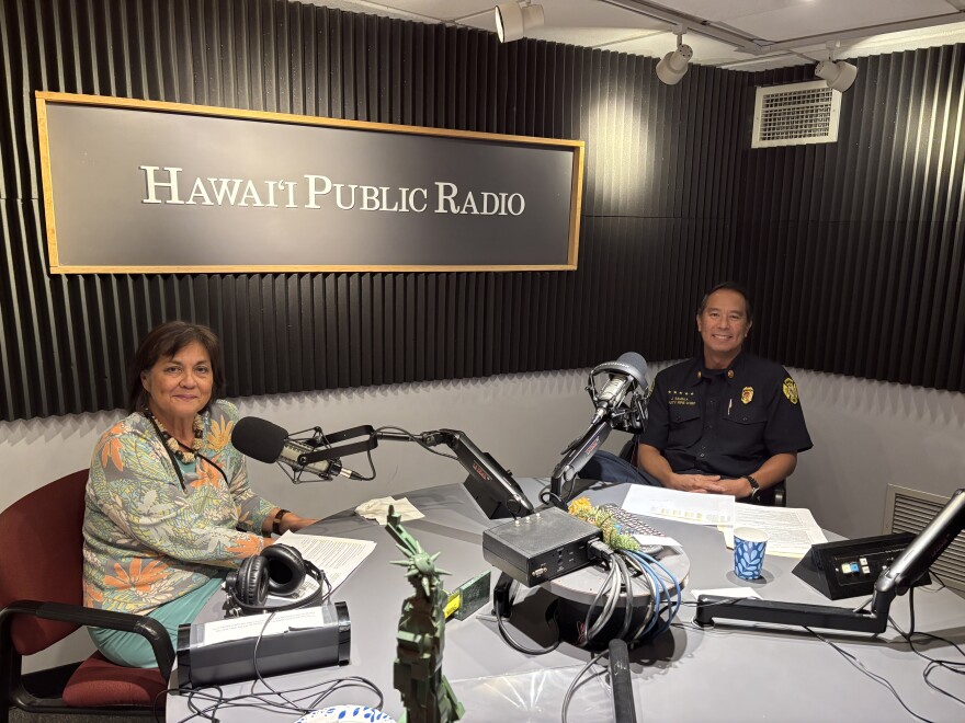 Honolulu Fire Department Deputy Chief Jason Samala, right, with HPR's Catherine Cruz on Dec. 24, 2025.