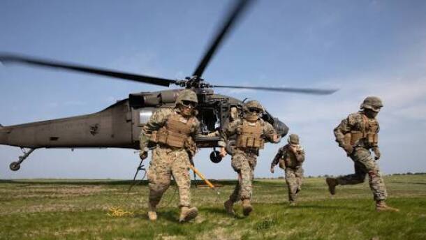 Army soldiers running from a helicopter