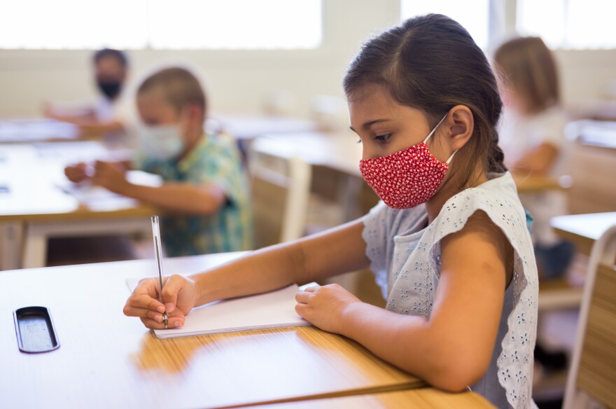 Student in face mask studying in class k-12 school masking