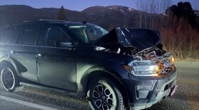 An SUV on a dark road with a smashed front end.