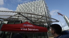 In this Jan. 16, 2018 file photo, a Visa Services gazebo stands outside the U.S. Embassy in London as visa applicants wait to go inside.