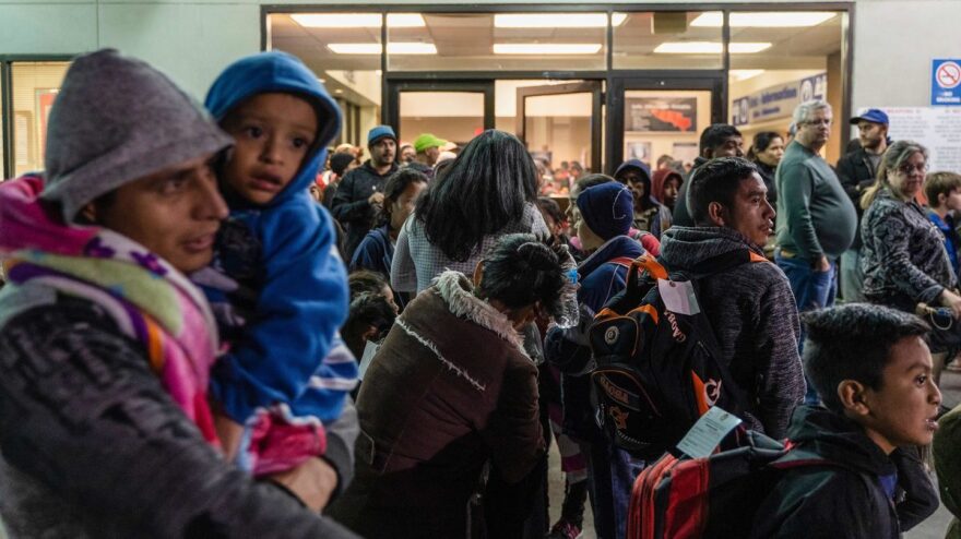 Asylum seekers stand at a bus stop after they were dropped off by Immigration and Customs Enforcement at the Greyhound bus station in El Paso, Texas on Dec. 23.