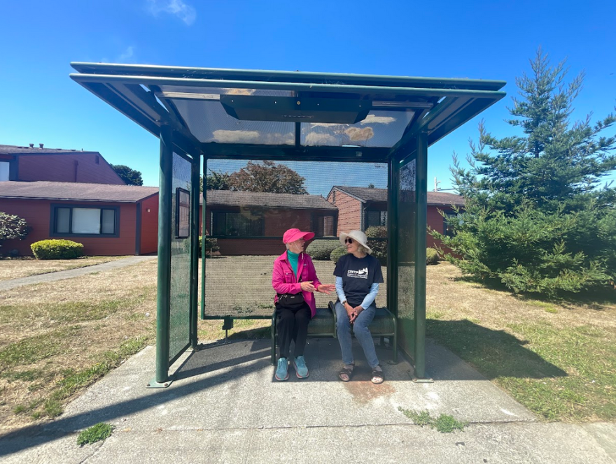 Two Humboldt County residents wait for public transit at a local bus stop.
