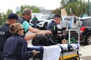Veterinarians and Police officers push a stretcher toward the hospital door. On the stretcher lays a black Labrador.