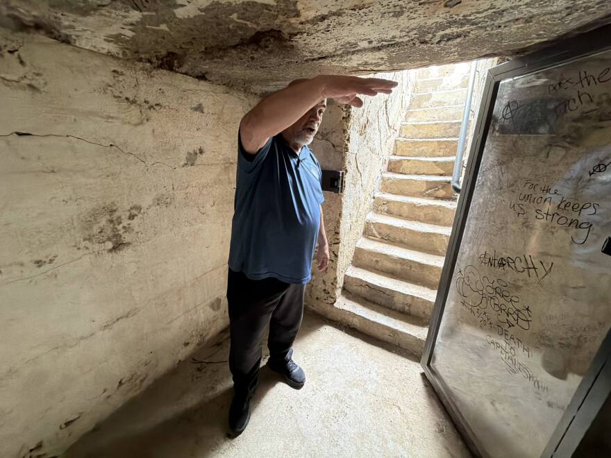 Bob Butero stands inside the preserved underground cellar where four women and 11 children sought shelter during the attack on the Ludlow tent colony. The original cellar was made from dirt and wood planks and had barely enough room for the group to stand.
