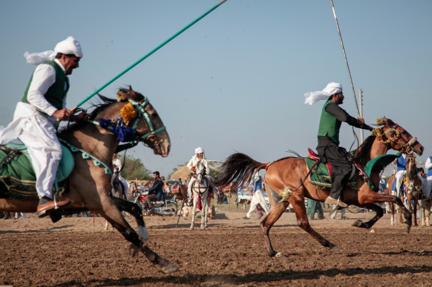 Men playing the ancient game of tent-pegging. Many of the riders are landowners and family. Playing the sport, and watching it, is one way farmers flaunt their wealth, much of it they credit for being built on the back of the Belorusian tractor.