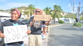 Pictured: Members of the Virgin Islands Progressive Movement hold signs calling for improvements to WAPA's electricity service during a protest outside the utility's newly leased Four Winds office on St. Thomas.