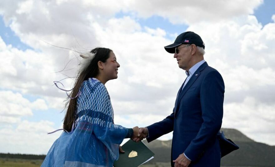 Maya Tilousi, member of the Hopi Tribe, Havasupai Tribe of Grand Canyon, and the Cheyanne and Arapaho Tribes, shakes hands with President Biden after introducing him at Red Butte Airfield, 25 miles south of Tusayan, Ariz., on Tuesday.