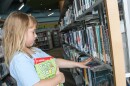 Elizabeth Etheridge, 6, looks through books at the Wichita downtown library on Monday. Federal cuts to the Institute of Museum and Library Services could impact Kansas summer reading programs.