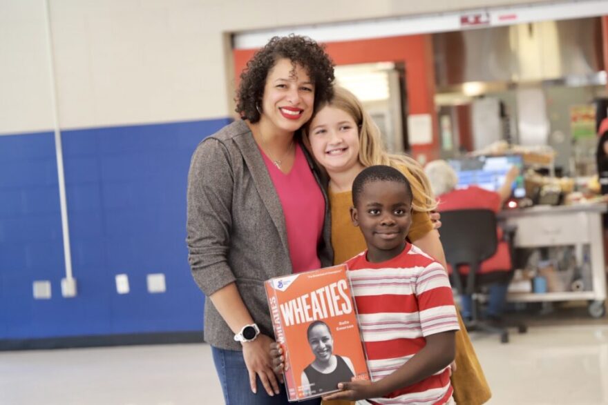 Dalla Emerson, food-service director for the Bowling Green Independent Schools, is congratulated by, from right, Wilondja Akili and Quinn Otto after General Mills honored her school-nutrition work by putting her photo on a Wheaties box. The students serve on the Child Nutrition Food Committee at McNeill Elementary