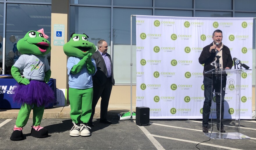 Toad Suck Daze mascots Dazey and Croaker W. Toad listen as Conway Area Chamber of Commerce CEO Brad Lacy speaks during a news conference in Conway on Thursday.