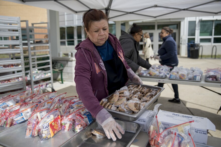 Jackie Nampha, a cafeteria worker at Washington-Liberty High School, helps with meal distribution in Arlington, Va.