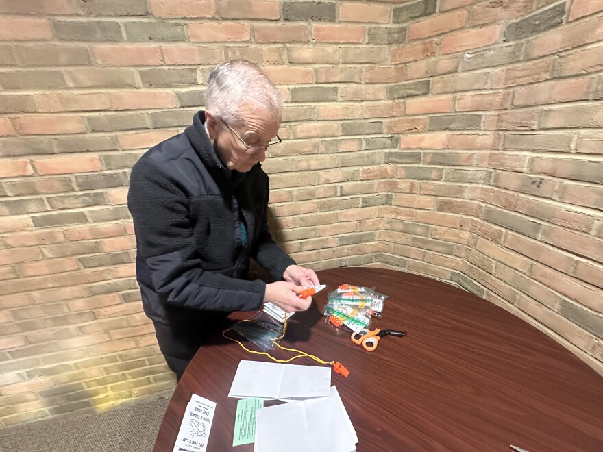 Fred Bartinstein assembles Orange Safety Whistle packs. The Springfield resident said community members will use them to alert when they see U.S. Immigration and Custom Enforcement (ICE) officers in the area or detaining a person.