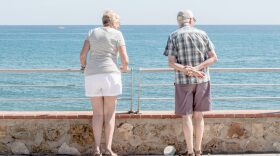 A couple of retired people look at the sea from the promenade in Benalmadena, Spain.