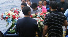 Two members of the Suleman family prepare to lay the wreaths during a memorial service honoring Haris Suleman who died and his father, Babar Suleman, who is missing after their plane crashed during an attempt to circumnavigate the world.