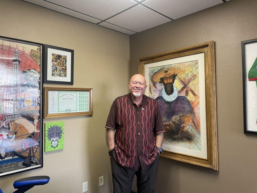 Carlos Gomez of the Latin Chamber of Commerce with a portrait of Don Quixote in his office. (Andie Corban/Marketplace)